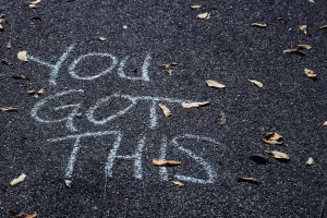 black sidewalk with "you got this" written in white chalk.