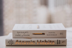 a stack of books about developing good habits placed on a desk.