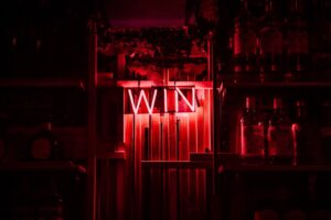 Red neon sign with the word win. You need to write a good scholarship essay to win it
