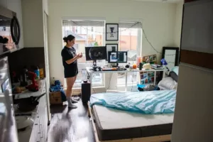 College student in her college dorm which is very messy