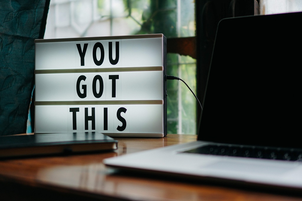 a sign sitting on a desk near a laptop that says you got this 