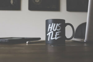 black coffee cup with the words hustle on it. the word represents side hustle ideas