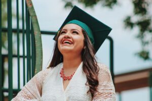 woman smiling in a college graduation cap