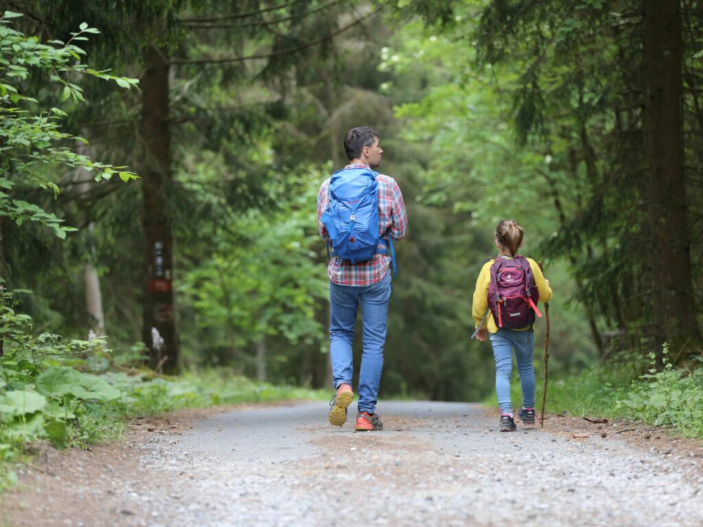 parent and child walking in the forest as they are homeschooling