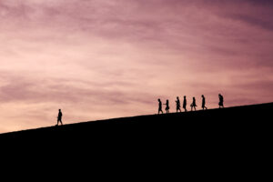 people on a hill following a leader